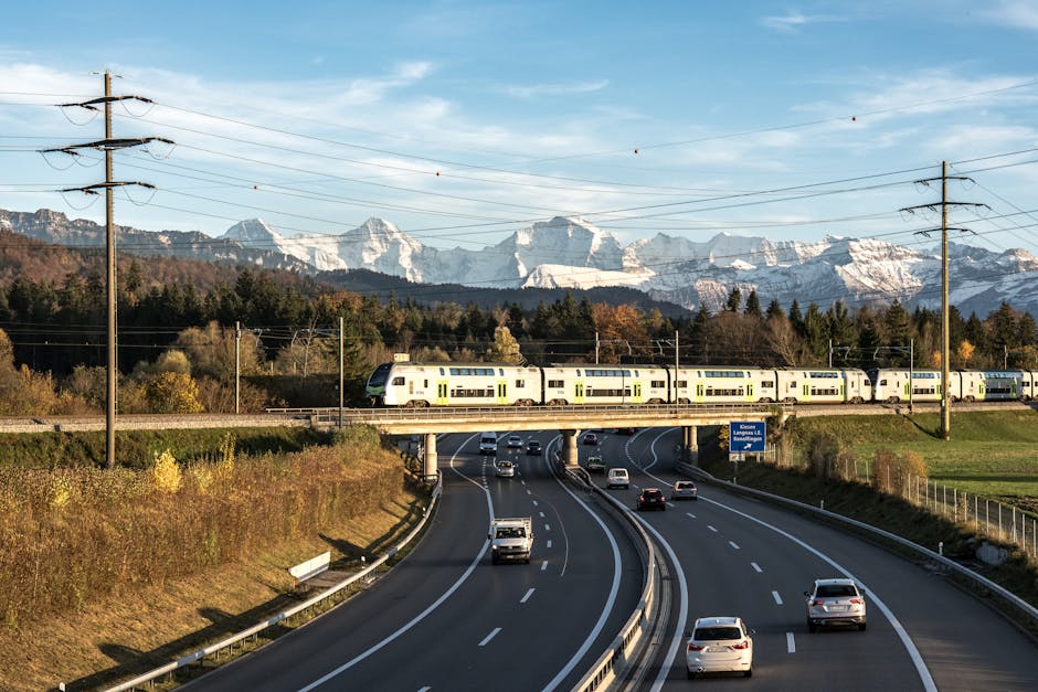 Highway and train in Bern with Swiss Alps backdrop. Ideal travel and infrastructure image.